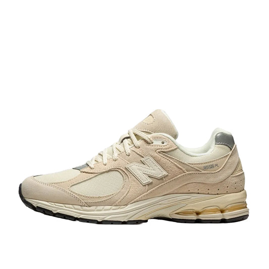 New Balance 2002R sneakers, side view, model M2002RCC, in off-white with subtle detailing.